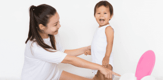 Six Signs Your Child is Ready to Potty Train mom and toddler standing with a potty chair