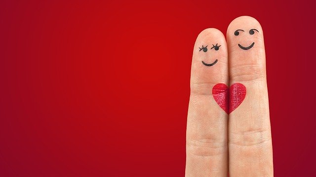 red background with two fingers up, decorated as people, with heart connecting them