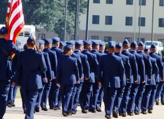 air force military airmen in blues marching with American flag