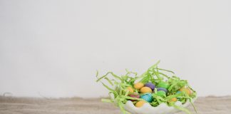 white platter with Easter grass and eggs on wood table