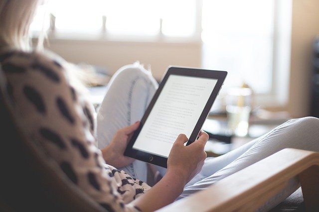 woman holding tablet and relaxing