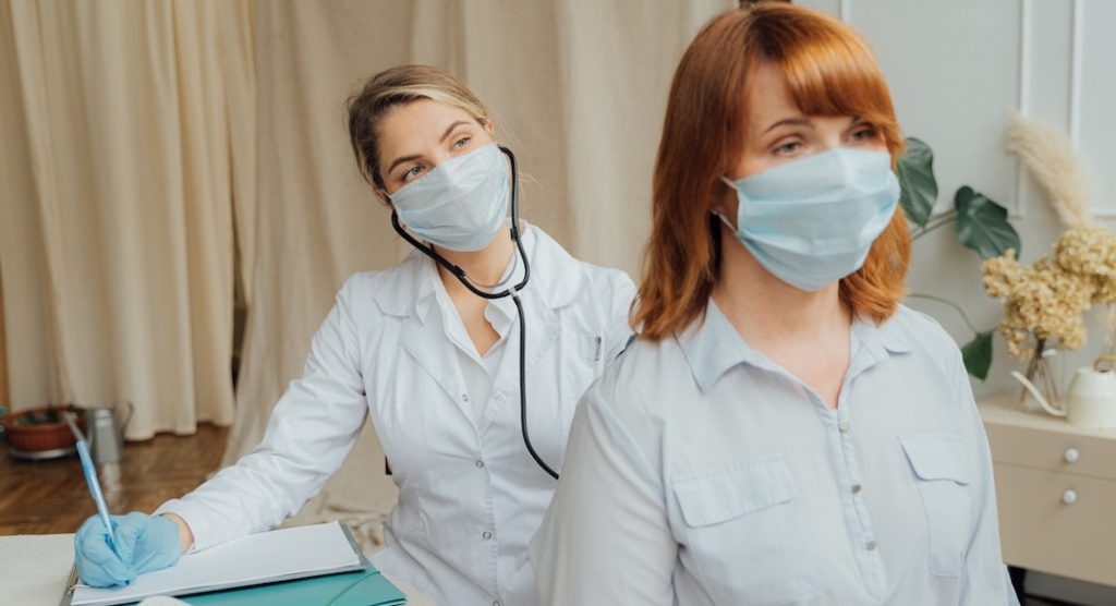 female doctor filling in chart with a female patient