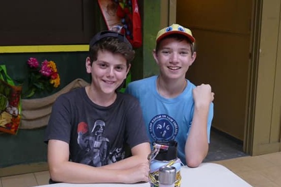 Two boys posing for a photo together at camp