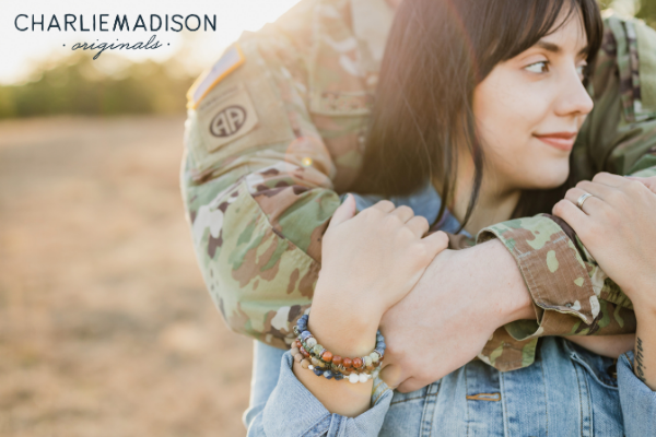 A service member with his arms wrapped around his spouse wearing Charliemadison Original bracelets. Charliemadison Originals is the perfect gift for military spouses and moms of all kinds.