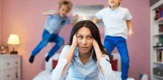 It’s OK to Not Enjoy Every Moment of Motherhood frustrated mother with kids jumping on the bed
