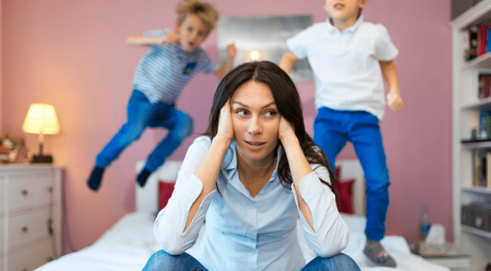 frustrated mother with kids jumping on the bed