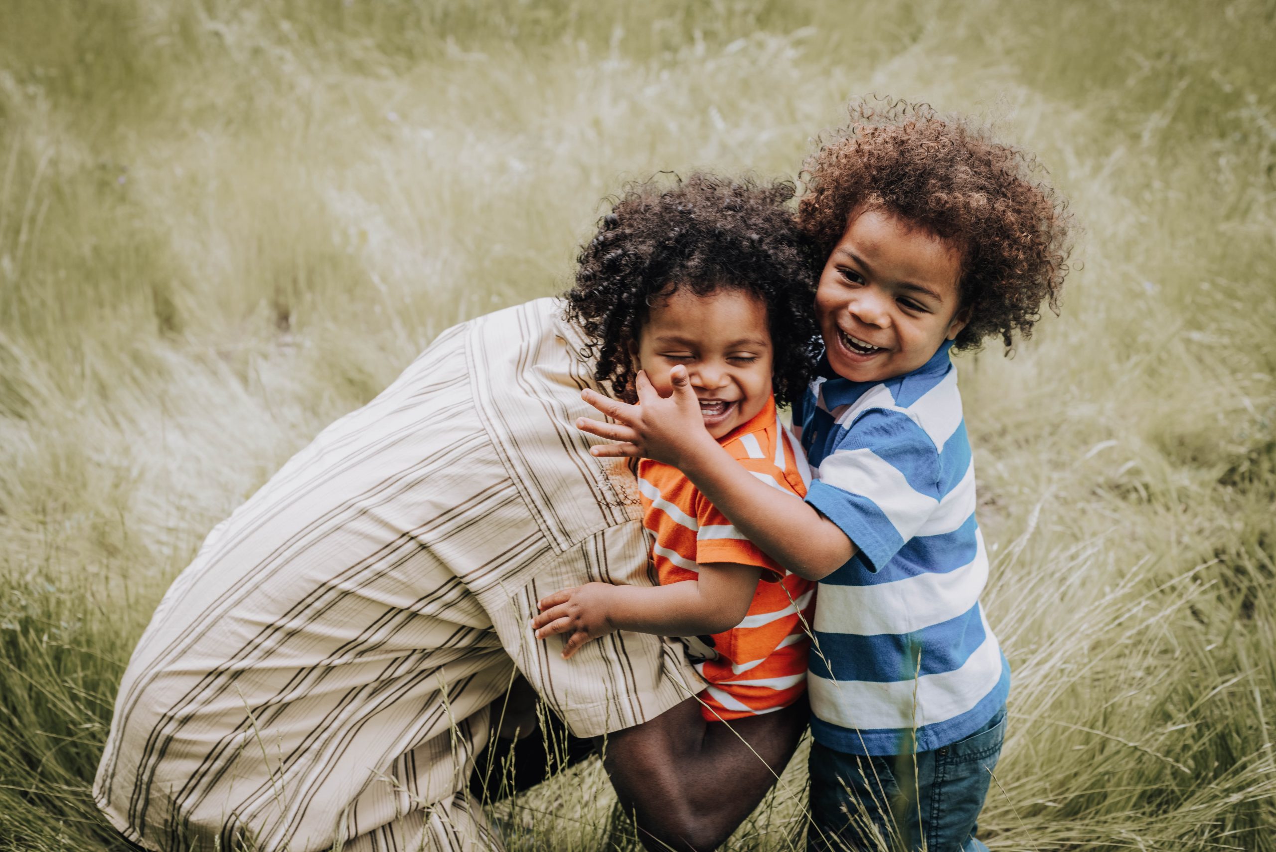 two black boys hugging a parent