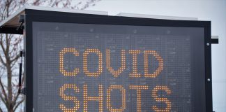 Worried About the COVID-19 Vaccine? Here’s My Experience large letter board with "COVID SHOTS" on screen