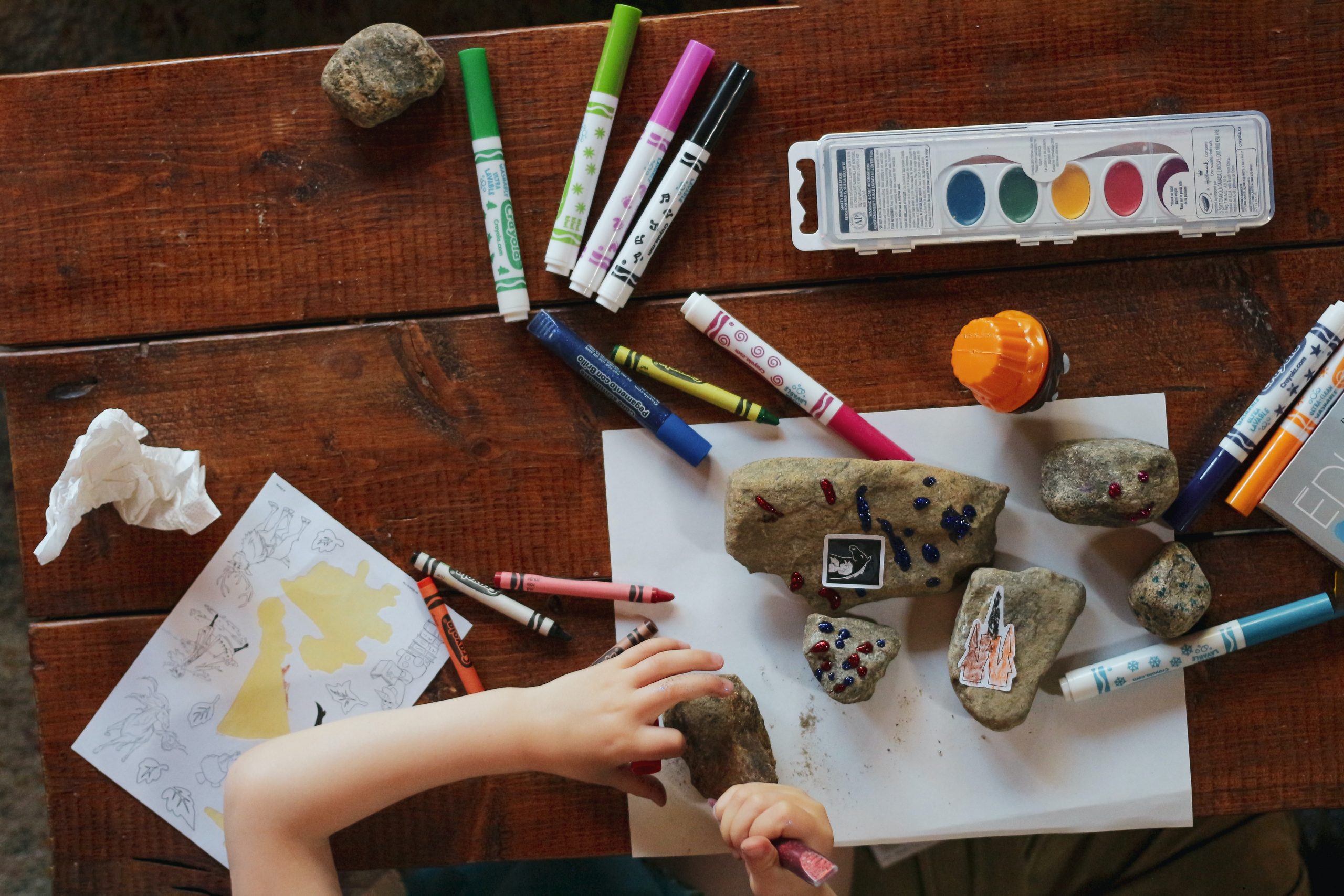 rocks and crayons and markers on a table