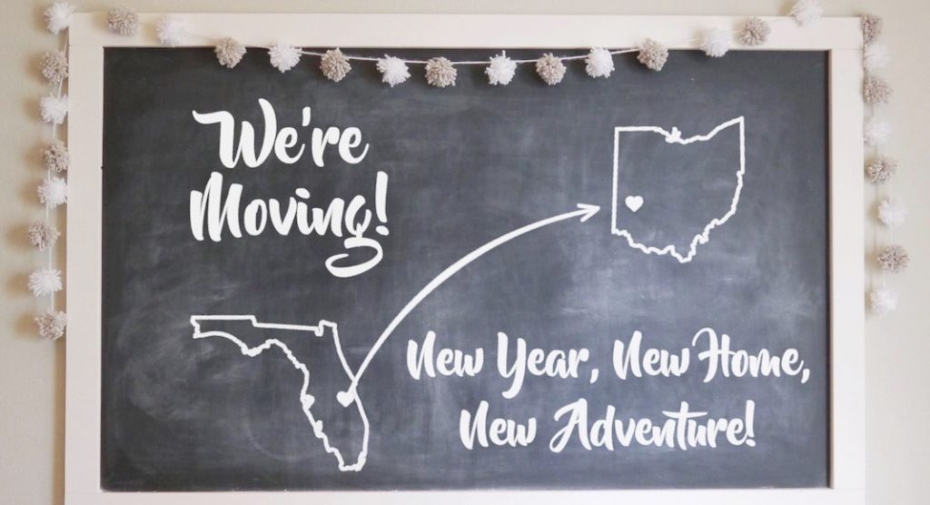 chalkboard with "we're moving! new year, new home, new adventure" written on it