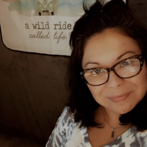 Annette Whittenberger in her studio with "A wild ride called life" banner