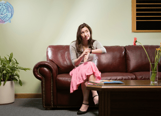 woman sitting on a couch looking at watch and waiting