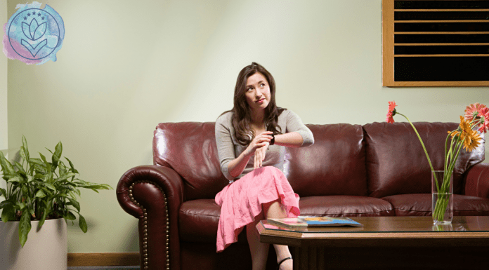 woman sitting on a couch looking at watch and waiting