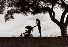 woman with a stroller outside in black and white