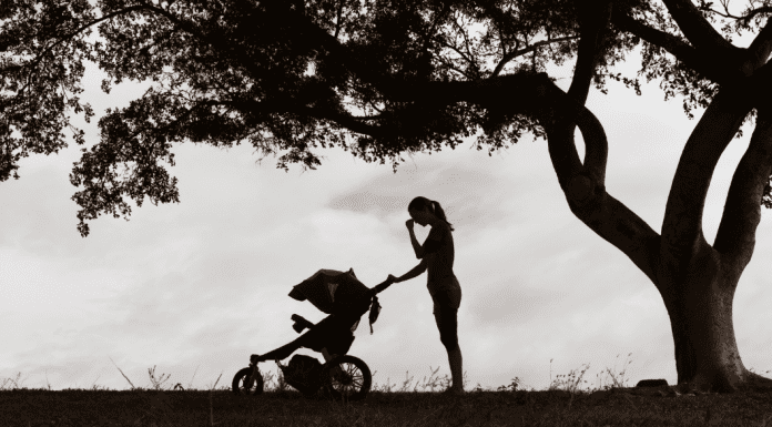 woman with a stroller outside in black and white