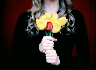 woman holding a bouquet of flowers in black to signify mourning