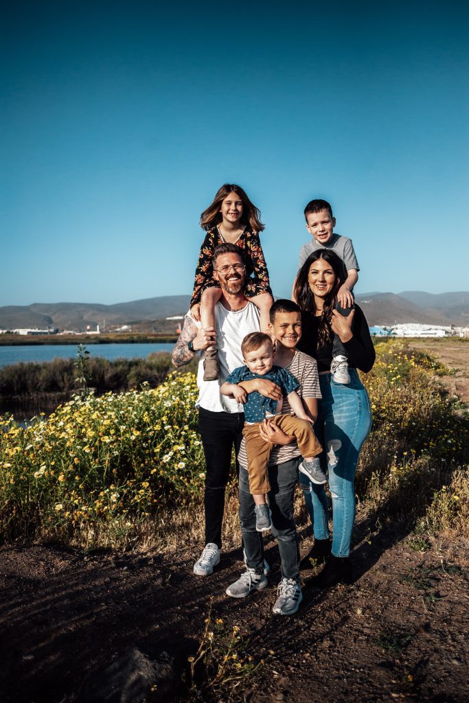 large family standing near the water