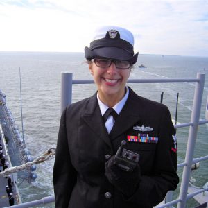 Female sailor in unifrom smiling on a ship in the ocean