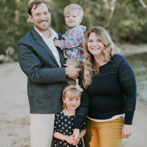 Copp Family - A husband, wife, little girl, and baby boy smiling on the beach