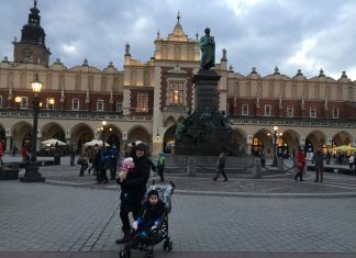 Mother and children standing in the main square of Krakow, Poland 2016