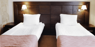 Unconscious Uncoupling: When a Sleep Divorce Might be Best two beds in the same room with a dark wood headboard