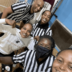 A group of five referees on the basketball court, 4 female, one male