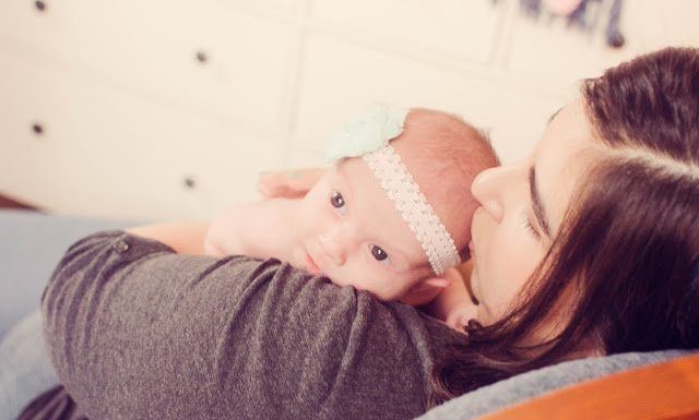 mom holding newborn baby on chest