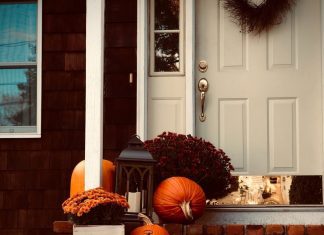 fall decor outside of a front door and porch