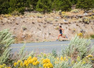 woman running on a road with dusty hillside in the background