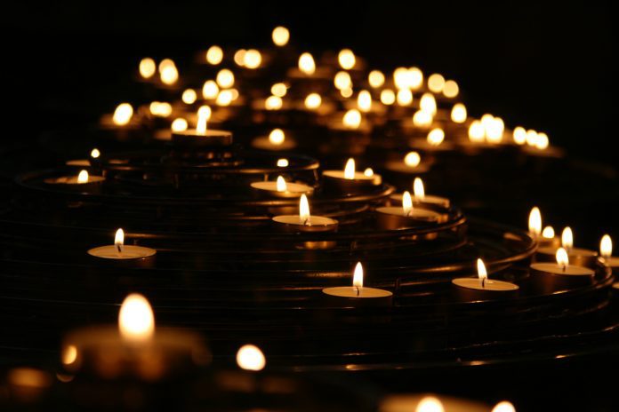 multiple lit votive candles to symbolize death or mourning