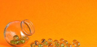 Non-Food Rewards for Kids A jar of marbles tipped on its side with many marbles spilled out