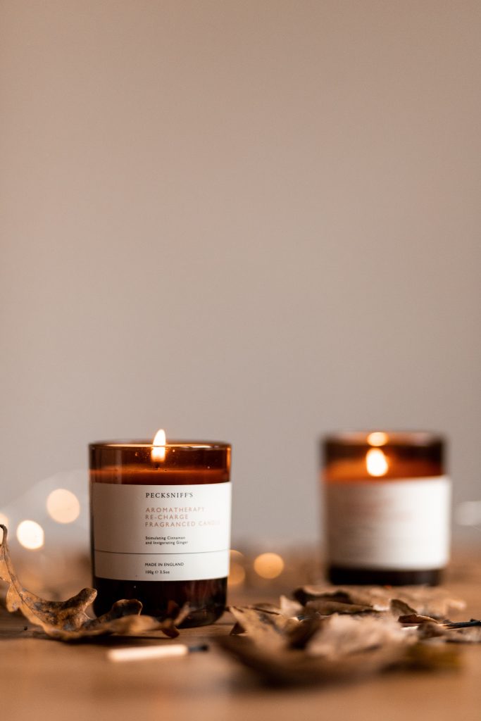 fall scented candles lit on a table with leaves