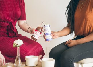 two women sitting together with food and drinks