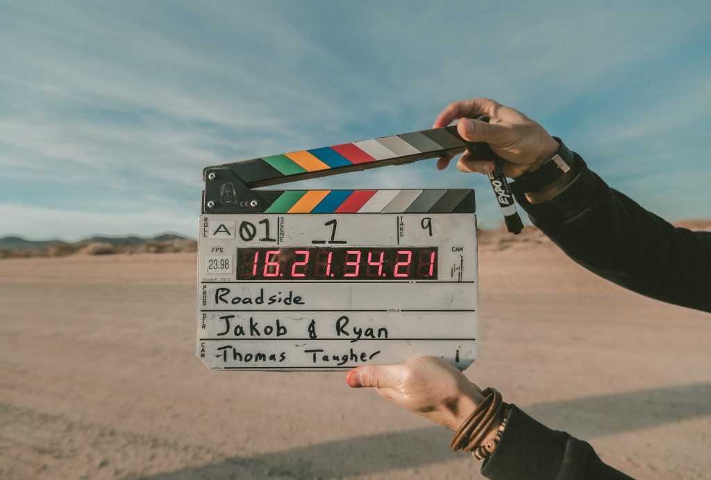 person holding a movie clapper in a desert scene