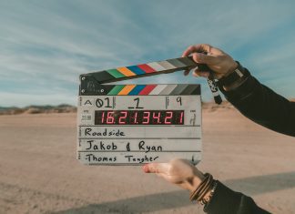 person holding a movie clapper in a desert scene