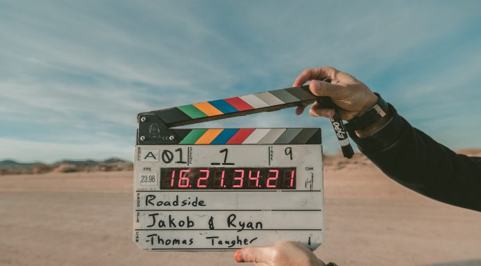 person holding a movie clapper in a desert scene