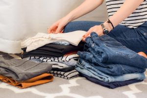 woman folding piles of clothes