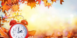 Getting Your Kids Back on Schedule When the Clocks “Fall Back” fall leaves and a sunny background with a red alarm clock