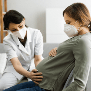 doula and a pregnant woman wearing masks