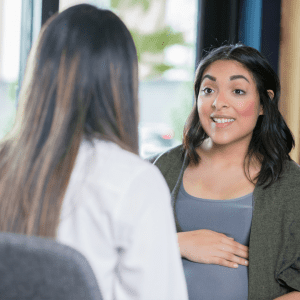 pregnant woman speaking with another woman