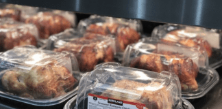 Costco rotisserie chickens in packaging under a warmer