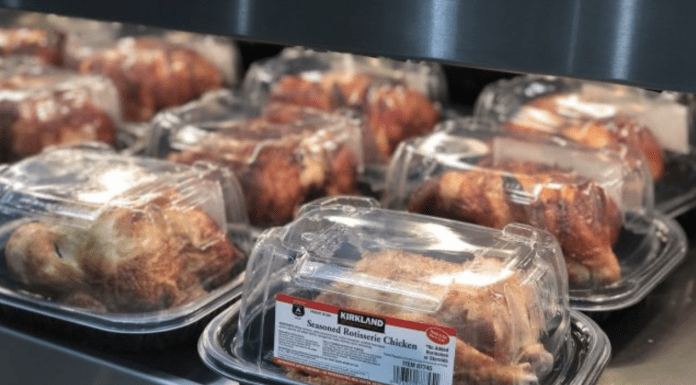 Costco rotisserie chickens in packaging under a warmer