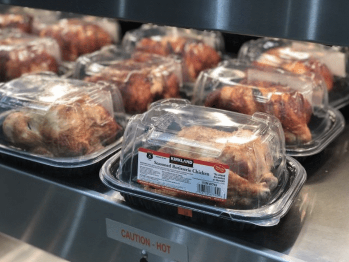 Costco rotisserie chickens in packaging under a warmer