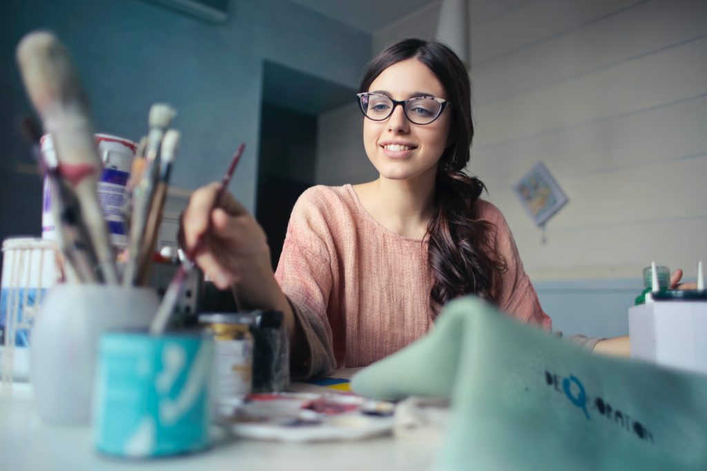 woman painting with craft supplies