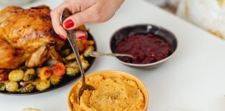 thanksgiving meal with turkey, sweet potatoes, and cranberry sauce on a white table