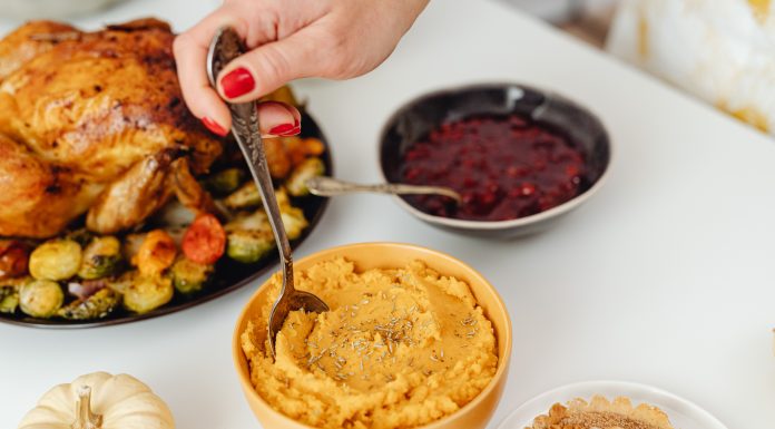 thanksgiving meal with turkey, sweet potatoes, and cranberry sauce on a white table