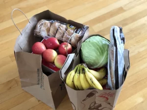 brown paper grocery bags full of produce and bread