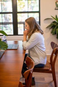 woman sitting at a table with a laptop