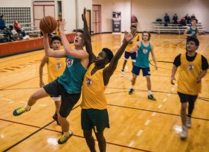 group of young boys playing basketball indoors