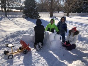 4 kids building a snow fort